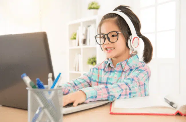 A picture of a student sitting in front of her computer at home attending a distance learning online.