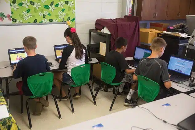 Group of Students studying in front of computer inside their library.