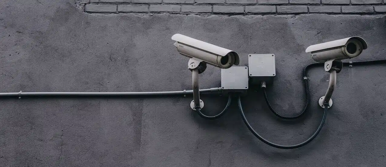 two security cameras mounted on a wall