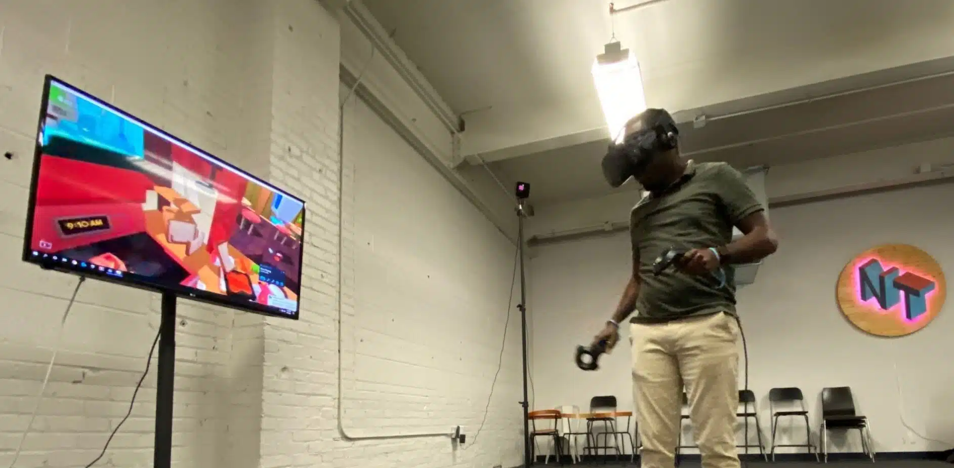 A man standing in front of a tv with a vr headset