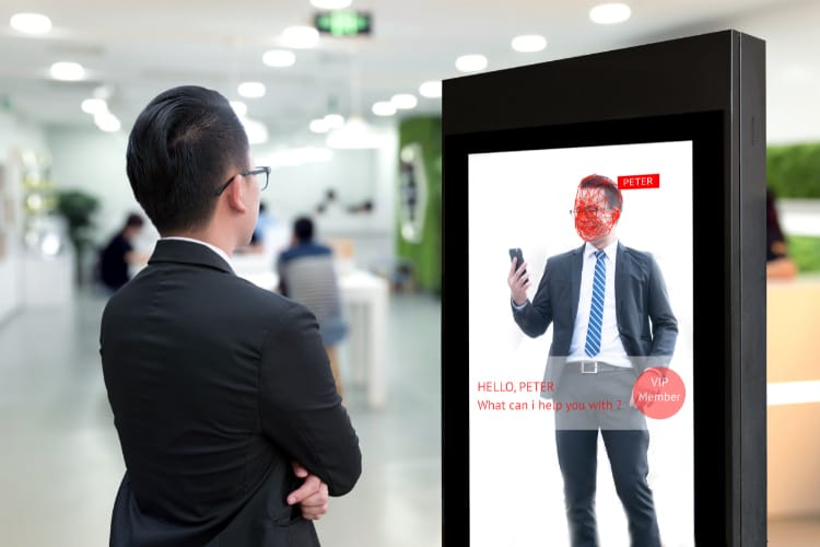 Male employee standing in front of digital signage.