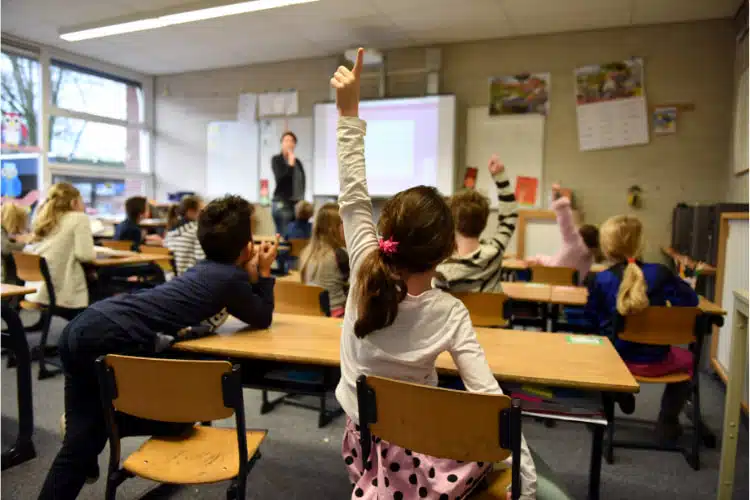 Teacher using digital screen signage to teach students at school.