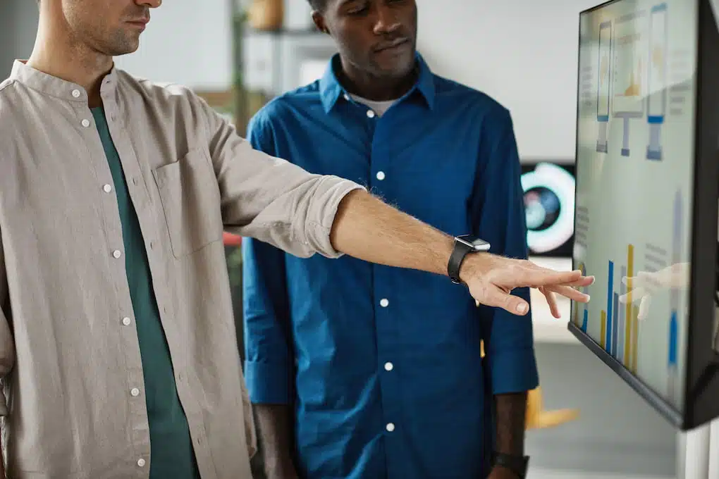 Employee's touching digital screen to check the onboarding training lessons.