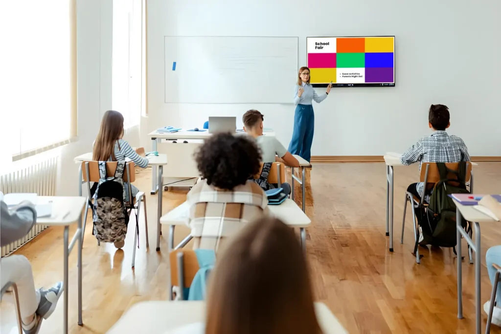 Teacher using digital screen signage to teach students at school.