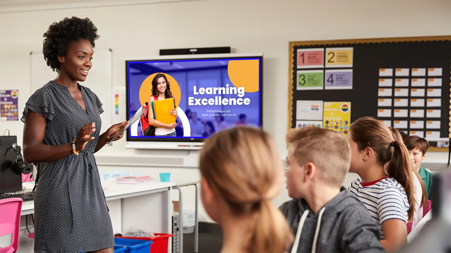 Teacher using digital screen signage to teach students at school.