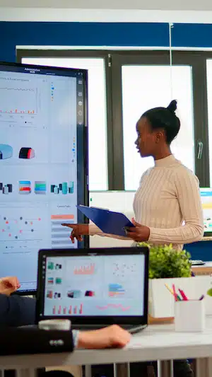 Black woman worker explaining company statistics in front of colleagues