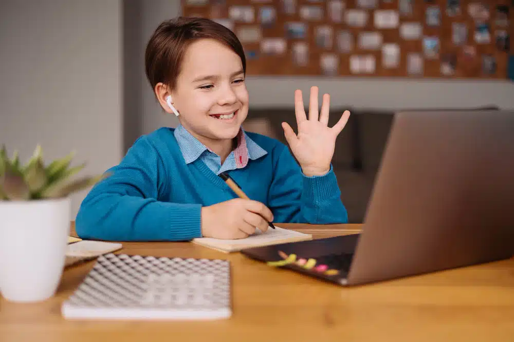 boy uses a laptop to make online classes