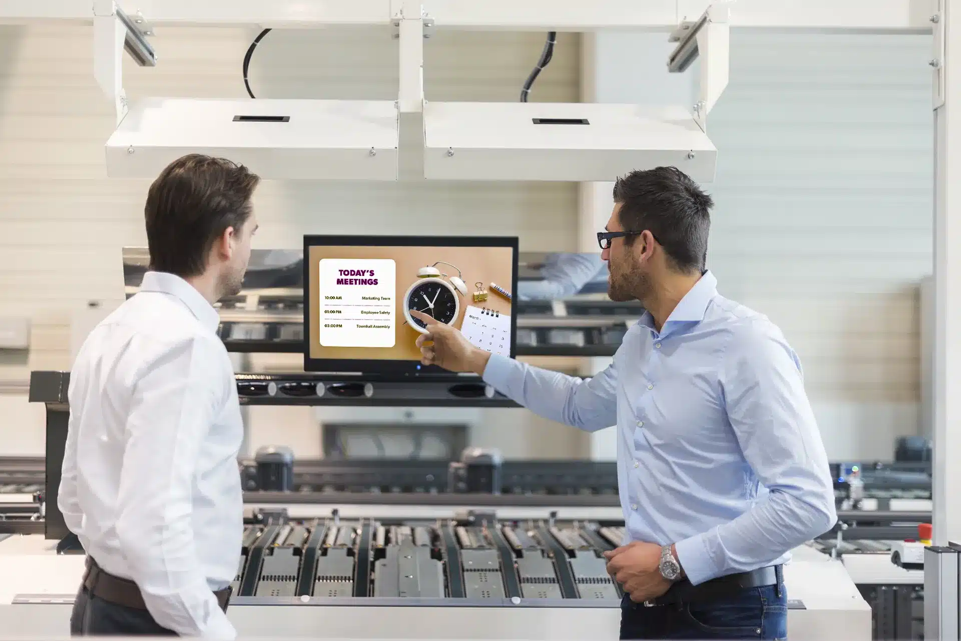 Industrial Workforce with Real-time Performance Management through Digital Signage: 2 man in the office using digital signange for performance management