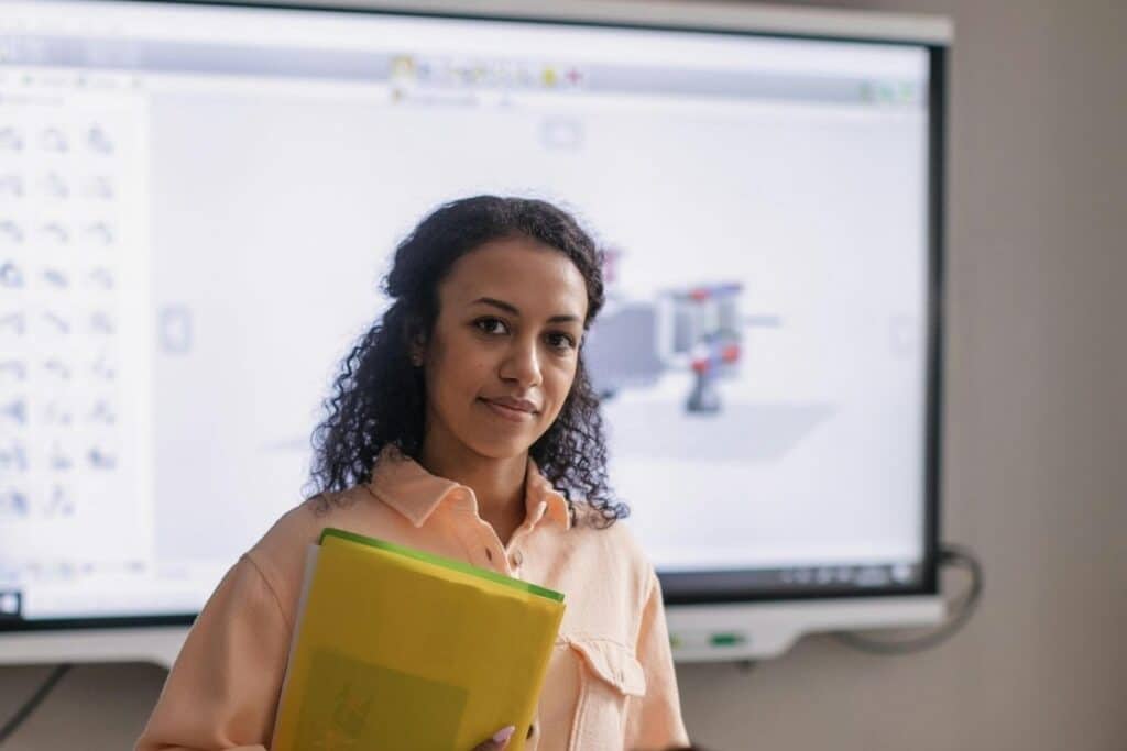 A Woman Wearing Yellow Folder Standing Near a Boy while Looking at the Camera
